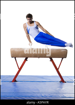 Male gymnast performing routines on vaulting horse Stock Photo