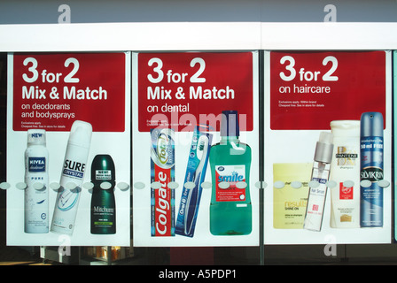 Very large Mix & Match advertising in high street shop front window promoting 3 for 2 special offers on deodorants dental and haircare products UK Stock Photo