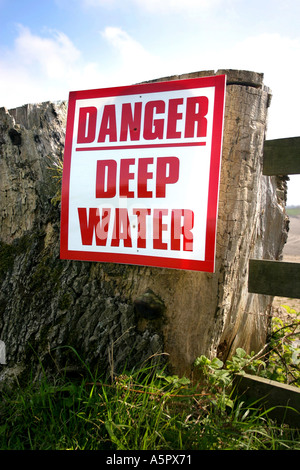 Danger deep water sign post with water behind Stock Photo - Alamy