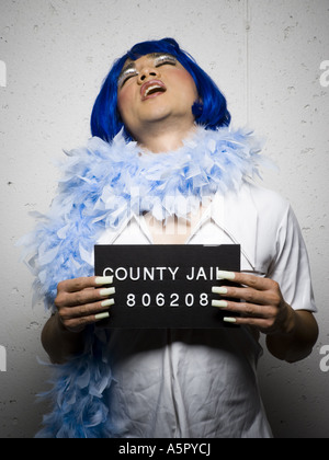 Mug shot of man in drag with blue wig and feather boa Stock Photo