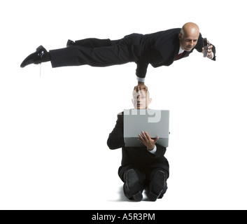 Two male acrobats in business suits performing Stock Photo