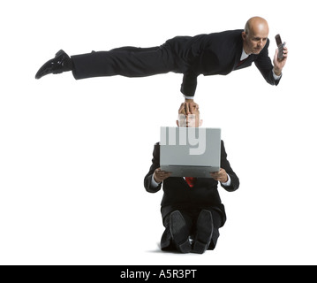 Two male acrobats in business suits performing Stock Photo