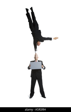 Two male acrobats in business suits performing Stock Photo