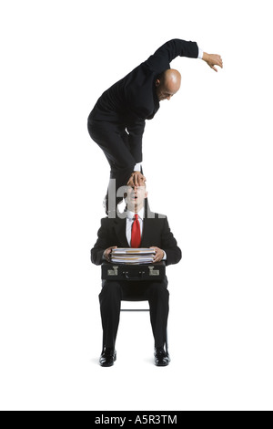 Two male acrobats in business suits performing Stock Photo