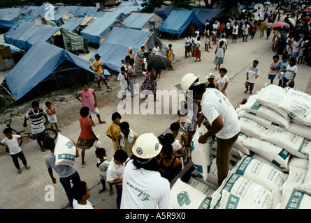 THE RED CROSS DISTRIBUTES MEAGRE RATIONS OF RELIEF FOOD TO EVACUEES IN A CAMP IN FLORIDA BLANCA 4 SMALL TINS OF SARDINES 2 TINS Stock Photo