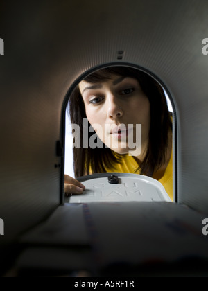 Close up of a young woman checking a mailbox for mail Stock Photo