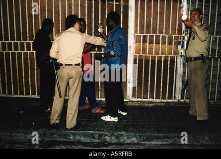 ILLEGAL IMMIGRANTS POLICE QUESTIONING WEST AFRICANS FOR THEIR IDS AND SEARCHING FOR DRUGS ON NIGHT PATROL ON THE STREETS OF Stock Photo