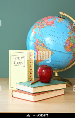 School still life; globe, report card, school books, red apple and pencil with chalkboard in background. Stock Photo