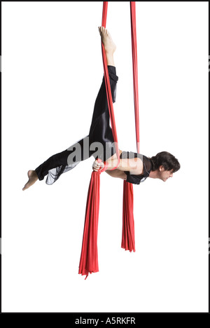 Male circus gymnast tangled in red drapes Stock Photo - Alamy