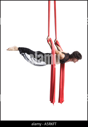 Male circus gymnast tangled in red drapes Stock Photo - Alamy