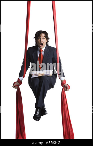 Businessman tangled in red drapes Stock Photo