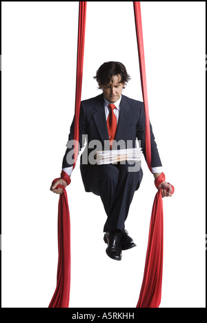 Businessman tangled in red drapes Stock Photo