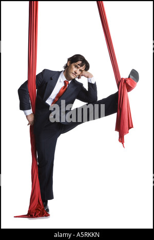 Businessman tangled in red drapes Stock Photo