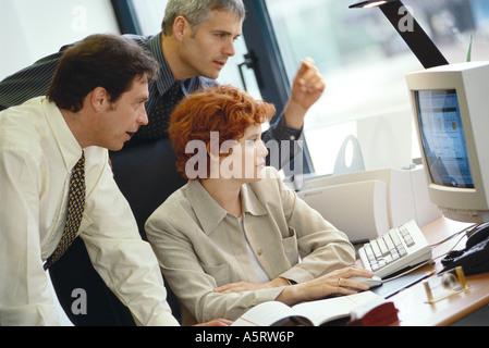 Business colleagues working at desktop computer together Stock Photo