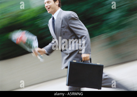 Businessman running with bouquet of flowers Stock Photo