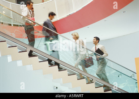 Business executives going up and down staircase Stock Photo