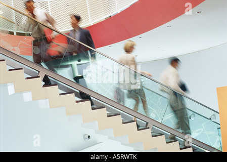 Business executives going up and down staircase Stock Photo
