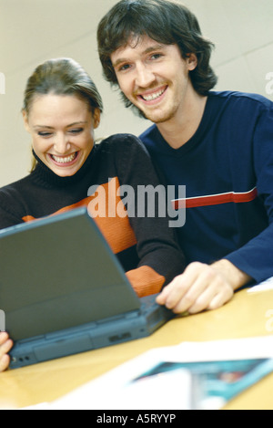 Couple using laptop, smiling Stock Photo