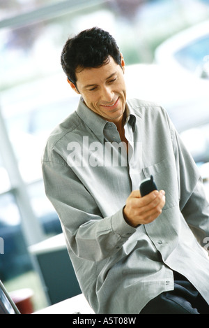 Man using cell phone, smiling Stock Photo