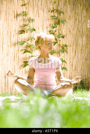 Senior woman doing yoga outdoors Stock Photo