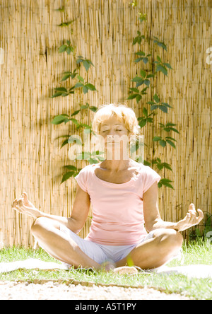 Senior woman doing yoga outdoors Stock Photo