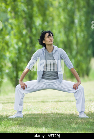 Young woman doing squats outdoors Stock Photo