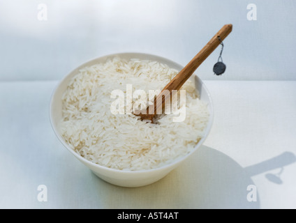 Bowl of rice and wooden spoon Stock Photo