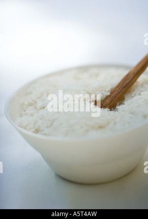 Bowl of rice and wooden spoon Stock Photo