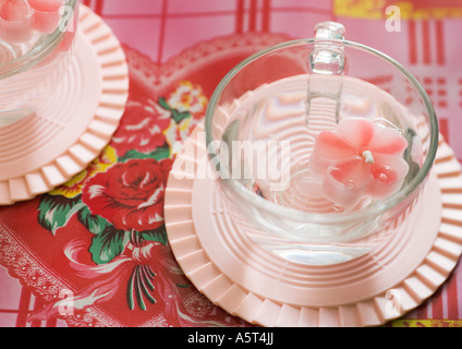 Flower-shaped candle floating in cup Stock Photo