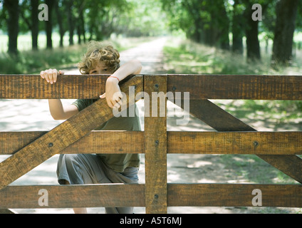 Boy climbing fence Stock Photo