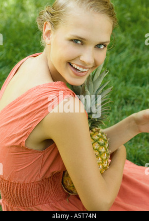 Woman holding pineapple on lap Stock Photo