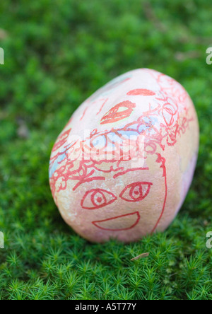 Stone decorated with face, lying on ground Stock Photo