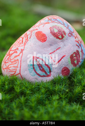 Stone decorated with face, lying on ground Stock Photo
