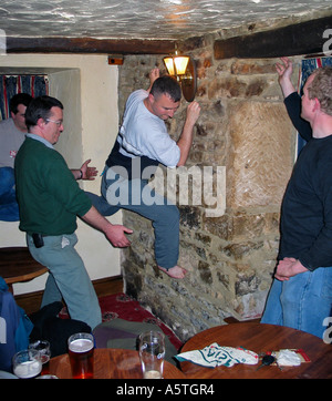 Young men indoor climbing the walls in an Inn after a few beers during a stag party weekend Stock Photo