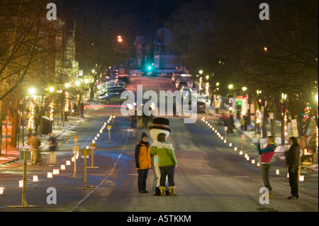 Candlelight stroll Christmas time Cooperstown New York luminaries on Main Street and snowman Stock Photo