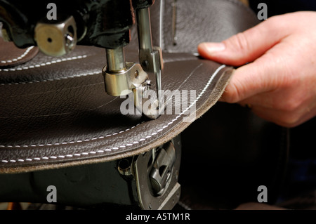 stitching leather on race horse saddle Stock Photo