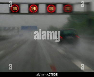 electric signs for speed limit above a moroway with bad sight on rainy ...