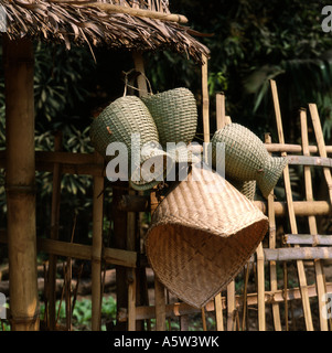 Traditional wicker baskets hang outside of rural house in small village,North Laos. Stock Photo