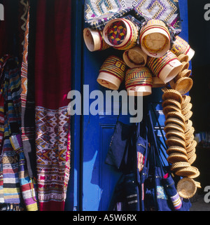 Traditional wicker baskets for sale hang in the sunshine on blue shop door,Luang Prabang, Laos. Stock Photo