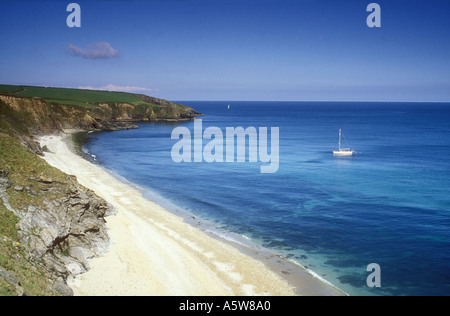 Yacht moored off Porthbeor Beach on the Roseland Peninsula in Cornwall in the UK Stock Photo