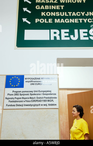 Poland, Lodz, woman standing at physical therapy centre door, side view Stock Photo