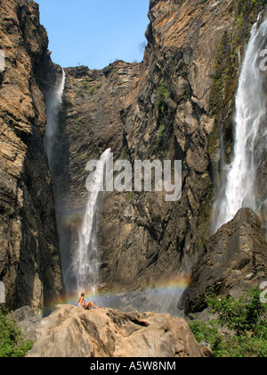 A man cools off in the spray of Jog Falls whilst admiring there natural beauty Stock Photo