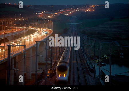 Eurostar train crossing the River Medway at night close to M2 Motorway on the High Speed One (Channel Tunnel Rail Link). Stock Photo