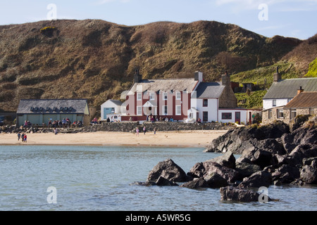 View across calm sea to Ty Coch Inn on a beach at Porth Dinllaen village in bay on Lleyn Peninsula North Wales UK Britain Stock Photo