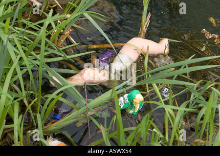 Toy doll and plastic waste dumped in polluted canal in radcliffe bury lancashire uk Stock Photo