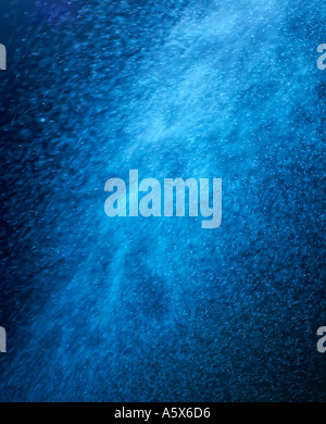ABSTRACT IMAGE OF BLUE PARTICLES SWIRLING IN TURBULENT AIR Stock Photo