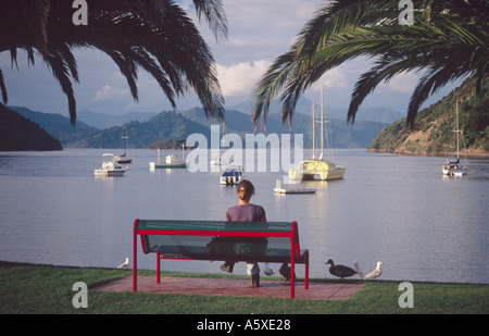 Person relaxing beside Picton harbour, New Zealand Stock Photo