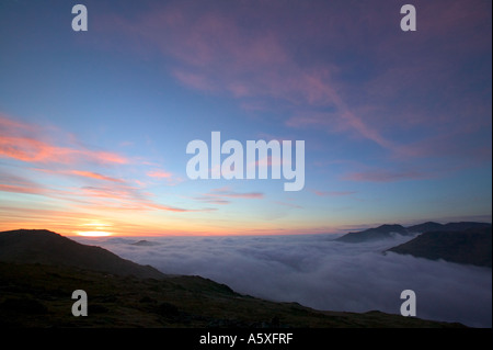 Harter Fell rising above the valley mist at sunset, from Little Carrs, Lake district, Cumbria, UK Stock Photo