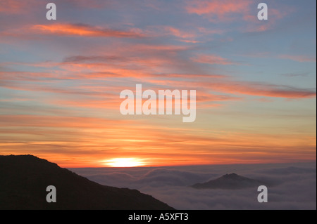 Harter Fell rising above the valley mist at sunset, from Little Carrs, Lake district, Cumbria, UK Stock Photo