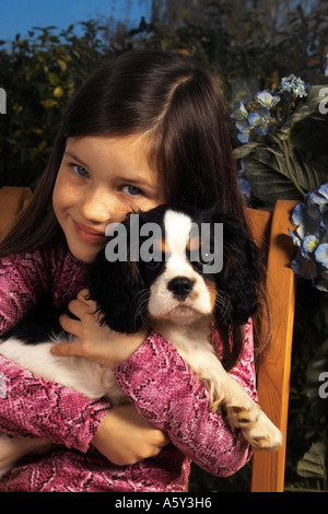 girl with Cavalier King Charles Spaniel puppy Stock Photo